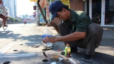   Câu cá ngay trên nắp cống đường phố Sài Gòn